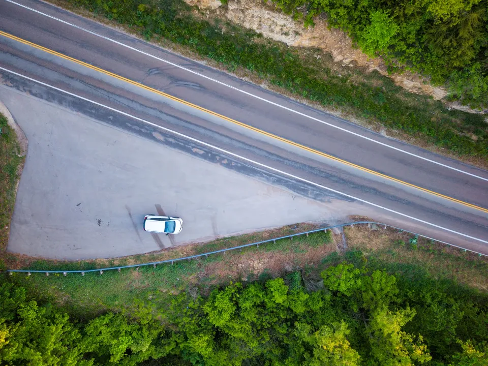 Drone photo of a highway and parked car in Weaver, Minnesota, surrounded by lush greenery.